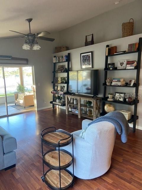 living room with dark hardwood / wood-style flooring and ceiling fan