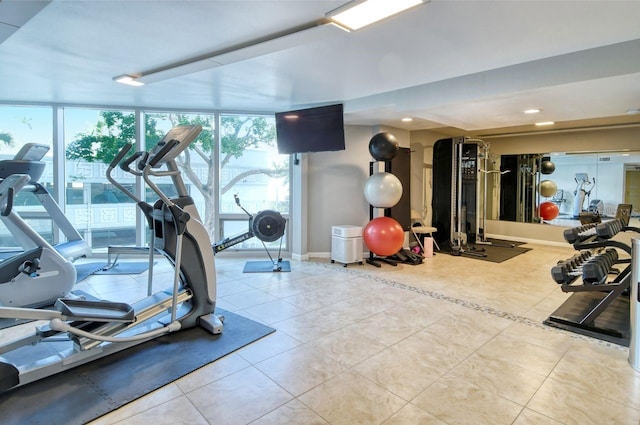 gym featuring tile patterned floors and a wall of windows