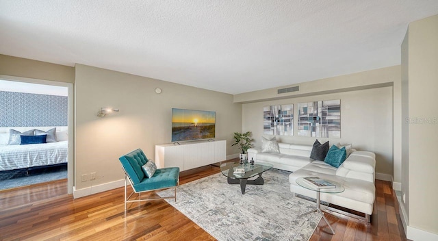 living room with hardwood / wood-style flooring and a textured ceiling