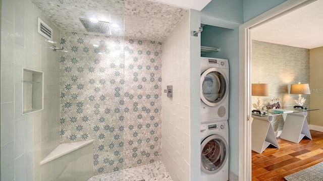 bathroom with stacked washer and dryer and wood-type flooring