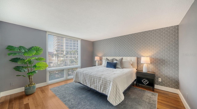 bedroom with hardwood / wood-style flooring and a textured ceiling