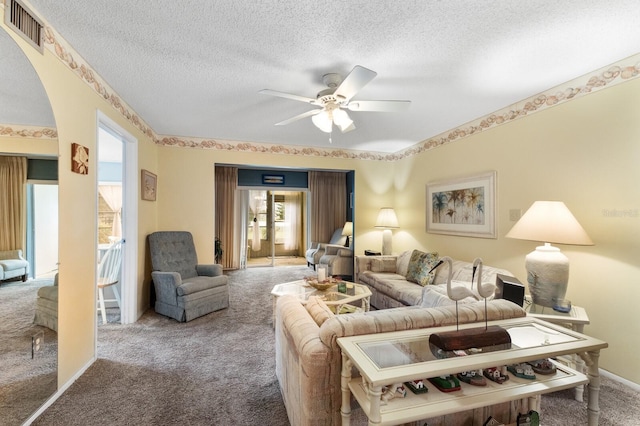 living room featuring carpet, ceiling fan, and a textured ceiling