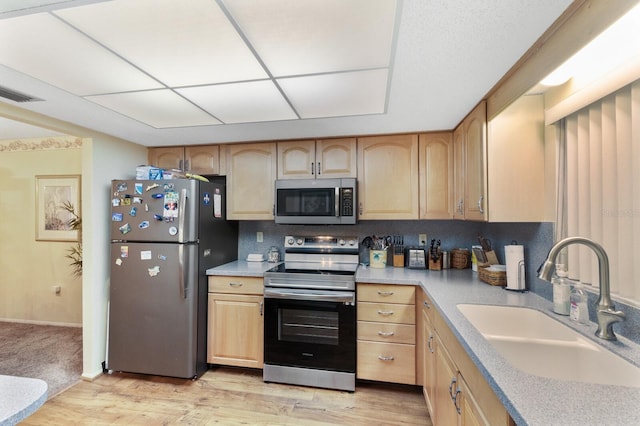 kitchen featuring appliances with stainless steel finishes, light hardwood / wood-style flooring, light brown cabinetry, and sink