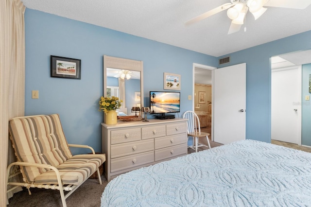 carpeted bedroom featuring ceiling fan and a textured ceiling