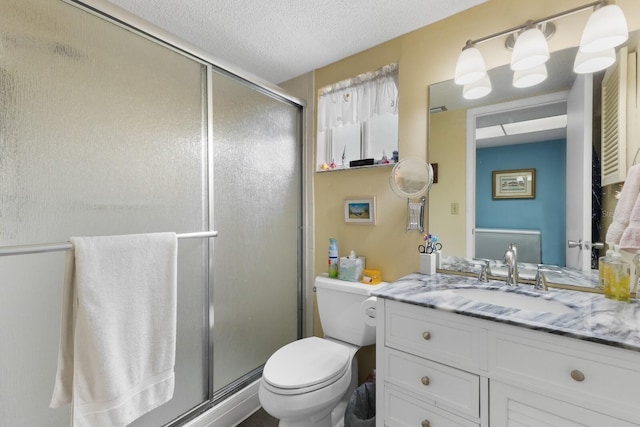 bathroom with toilet, vanity, a textured ceiling, and walk in shower