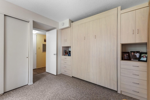 unfurnished bedroom with a closet, light colored carpet, and a textured ceiling