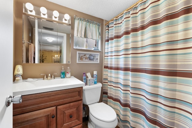 bathroom featuring a shower with curtain, vanity, toilet, and a textured ceiling