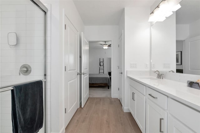 bathroom with ceiling fan, a shower with door, and vanity