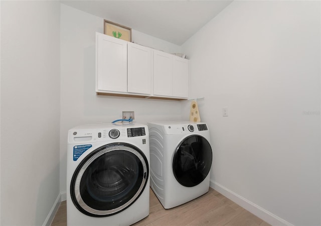 washroom with light hardwood / wood-style flooring, cabinets, and independent washer and dryer