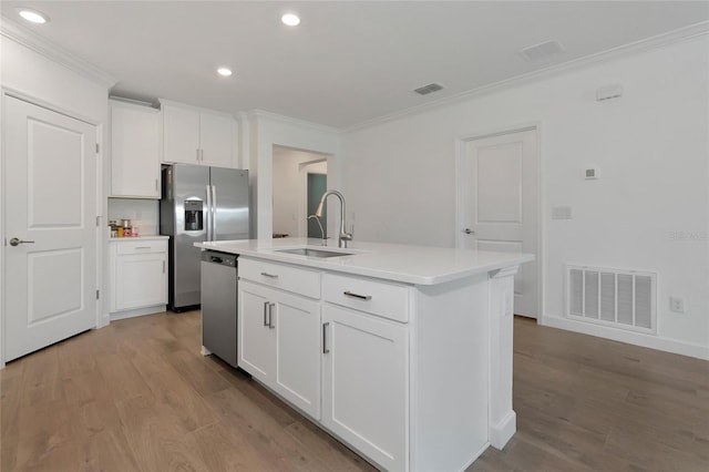 kitchen featuring a kitchen island with sink, appliances with stainless steel finishes, crown molding, sink, and white cabinetry