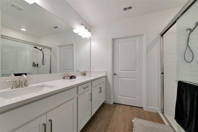 bathroom featuring hardwood / wood-style flooring, an enclosed shower, and vanity