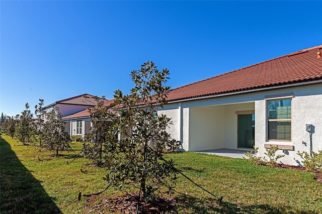 rear view of house featuring a yard and a patio