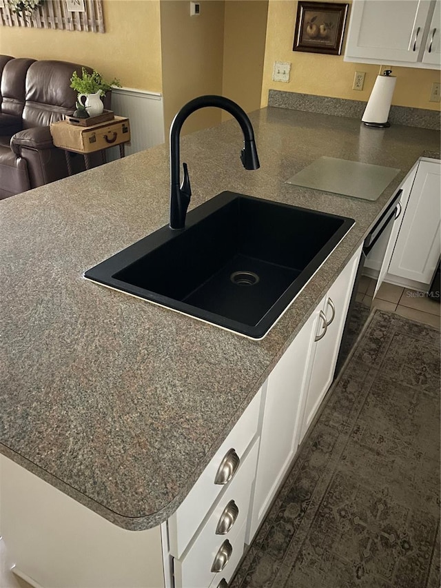 kitchen featuring white cabinetry, sink, dark tile patterned flooring, and kitchen peninsula