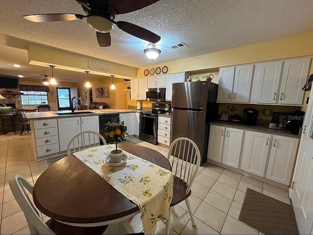 dining room featuring ceiling fan, sink, a textured ceiling, and light tile patterned floors