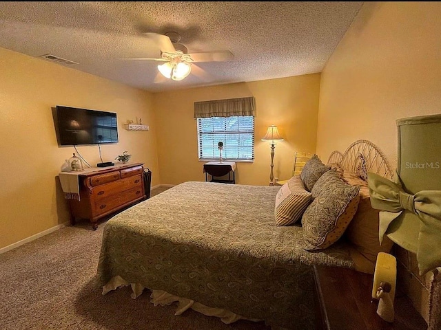 carpeted bedroom with ceiling fan and a textured ceiling