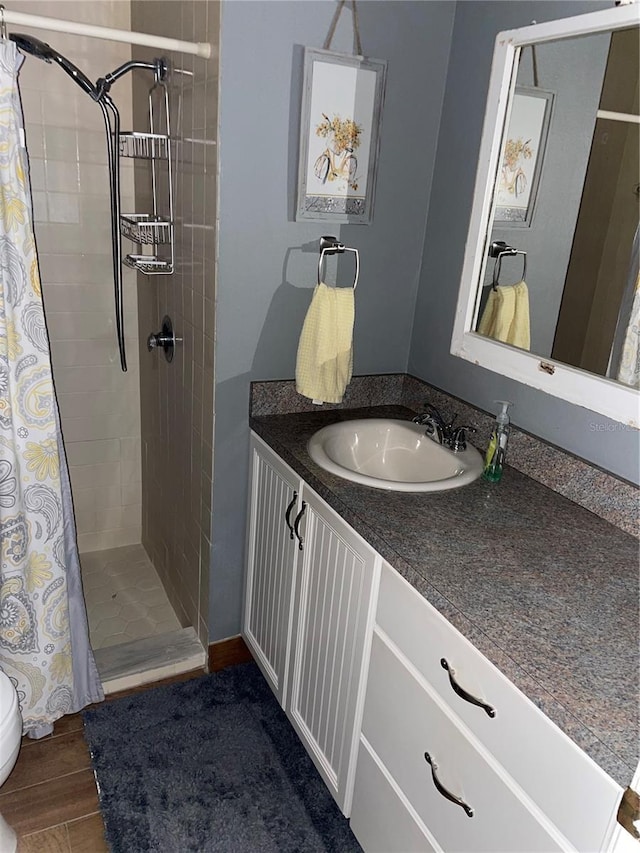 bathroom with hardwood / wood-style flooring, vanity, and curtained shower