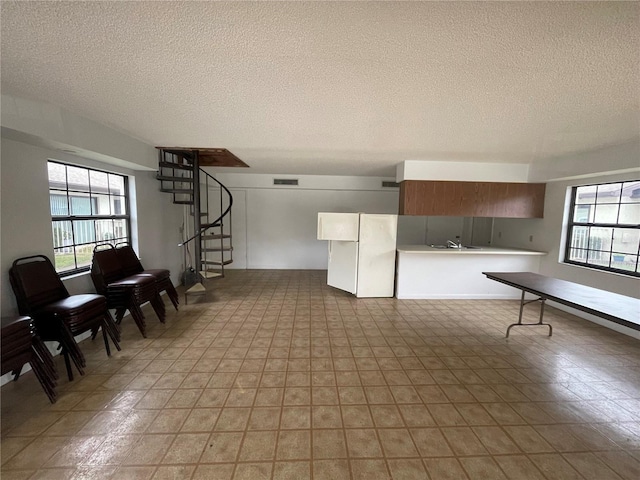 interior space with a healthy amount of sunlight, sink, and a textured ceiling