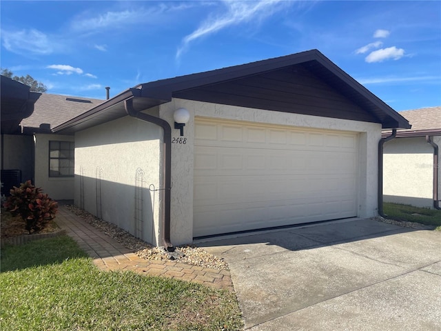 garage with driveway and central air condition unit