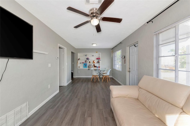 living room featuring ceiling fan and dark hardwood / wood-style flooring