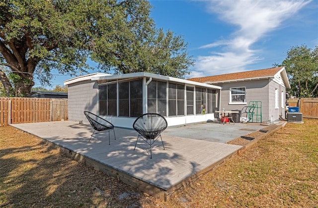 rear view of house featuring a deck, a sunroom, and a patio area