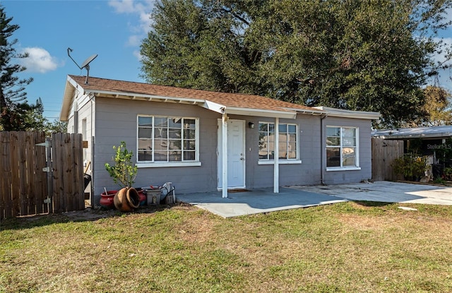 ranch-style home with a front yard and a patio