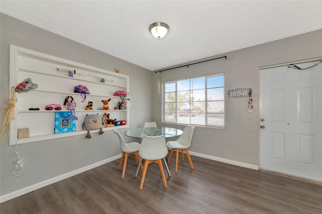 dining space featuring dark wood-type flooring and built in features