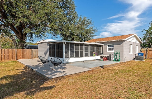 rear view of property with a patio, a sunroom, and a lawn