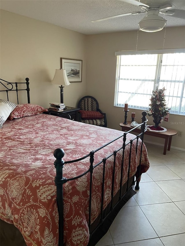 tiled bedroom featuring a textured ceiling and ceiling fan