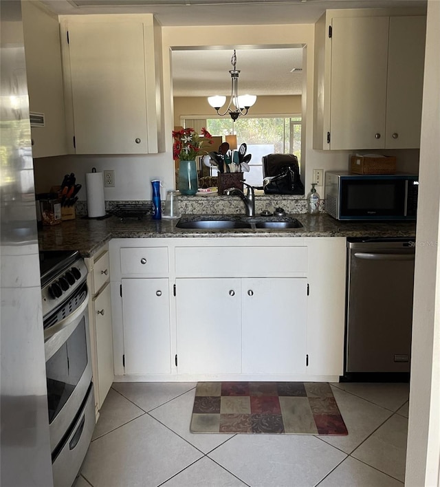 kitchen featuring sink, an inviting chandelier, light tile patterned floors, and appliances with stainless steel finishes