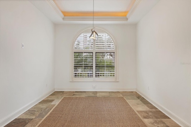 unfurnished dining area featuring crown molding and a raised ceiling