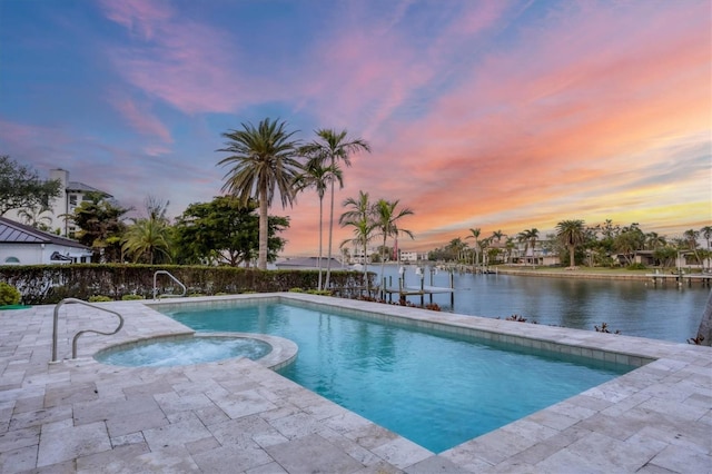 pool at dusk with a water view, an in ground hot tub, and a patio area