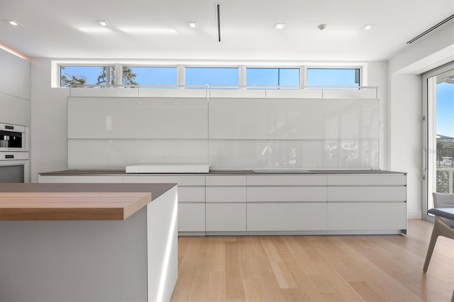 kitchen with light wood-type flooring and white cabinets