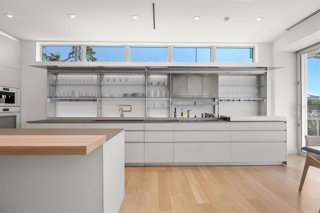 kitchen with light hardwood / wood-style flooring and white cabinets