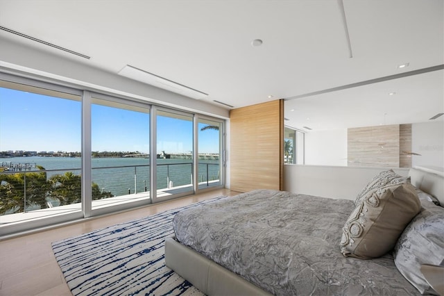 bedroom featuring a water view, access to exterior, and multiple windows