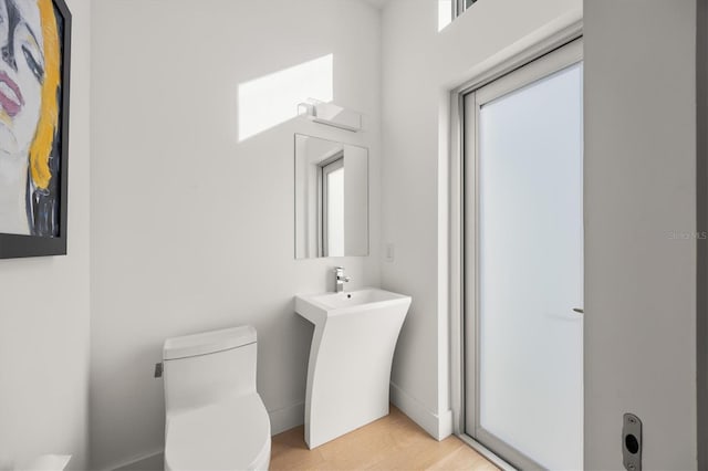 bathroom with wood-type flooring and toilet