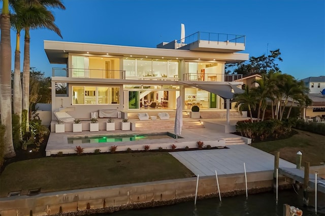 back of property featuring a patio area, a balcony, and a lawn