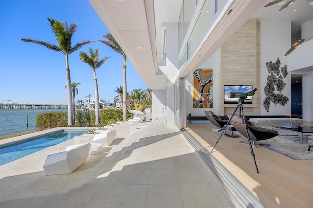 view of swimming pool featuring a water view and a patio