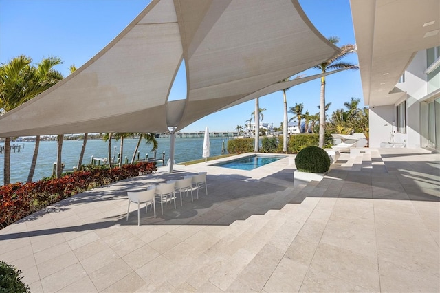 view of pool featuring a water view, a jacuzzi, and a patio