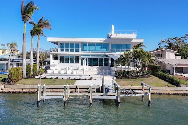 back of house with a yard, a balcony, and a water view