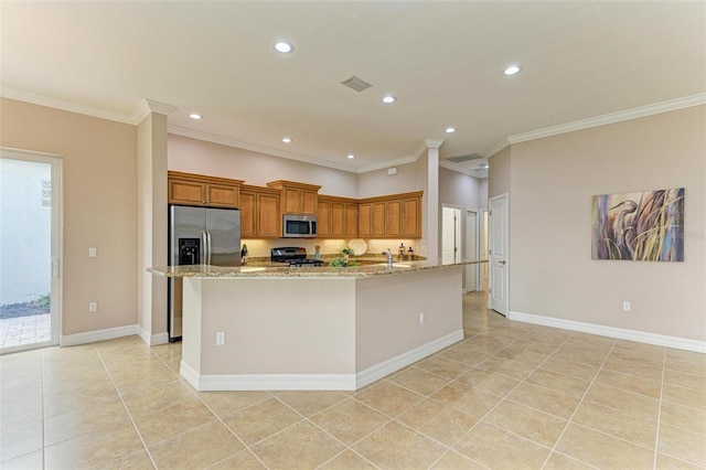 kitchen featuring light stone countertops, crown molding, appliances with stainless steel finishes, and an island with sink