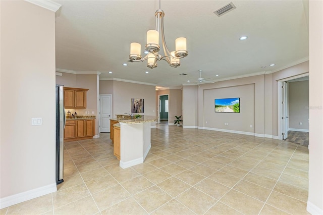 kitchen with hanging light fixtures, light tile patterned floors, light stone counters, and stainless steel refrigerator