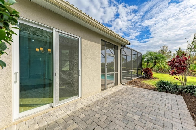 view of patio featuring glass enclosure