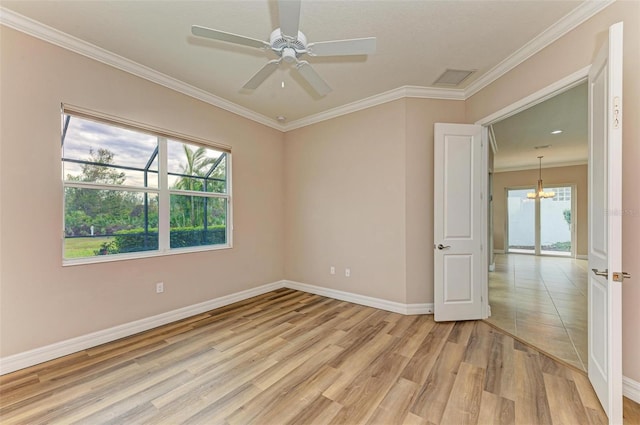 spare room with ceiling fan, ornamental molding, and light wood-type flooring