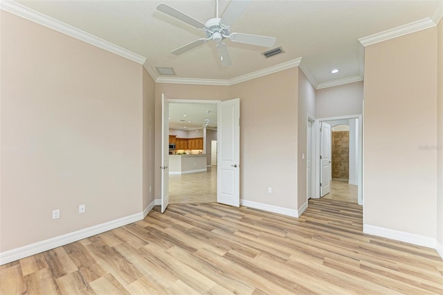 empty room with ornamental molding, ceiling fan, and light hardwood / wood-style flooring