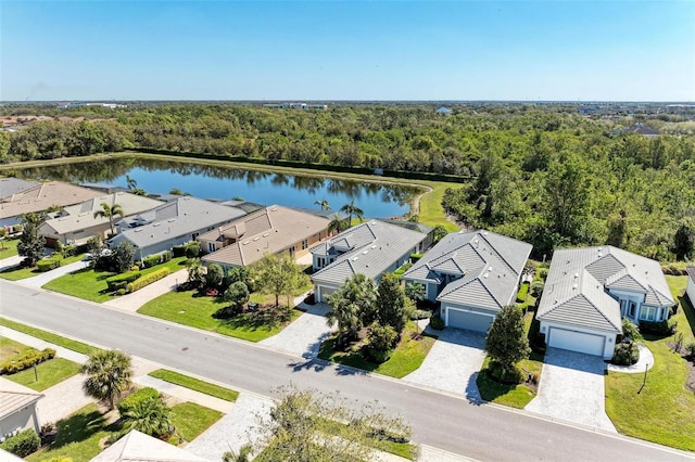 birds eye view of property featuring a residential view, a wooded view, and a water view