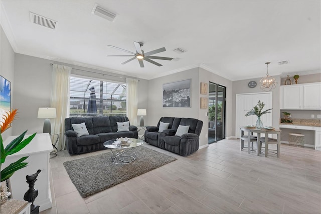 living room featuring ceiling fan with notable chandelier and crown molding