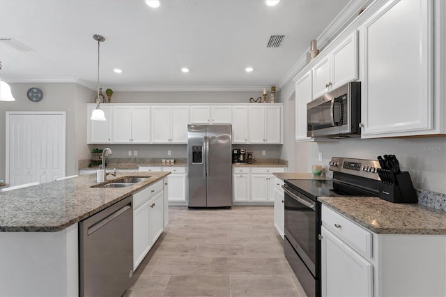 kitchen with an island with sink, stainless steel appliances, pendant lighting, white cabinets, and sink