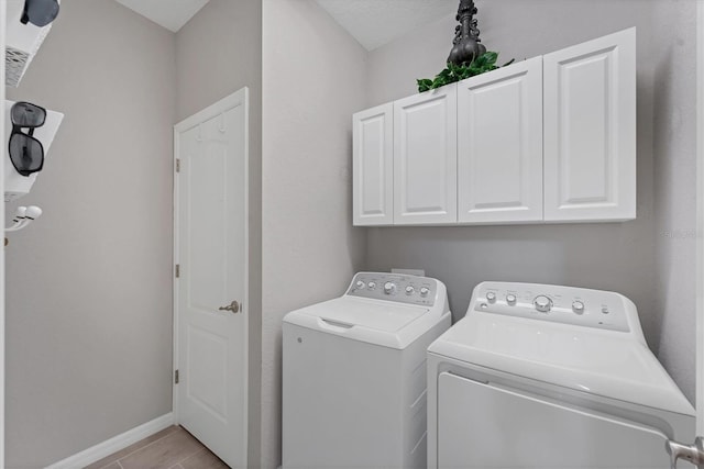 washroom with cabinets and separate washer and dryer