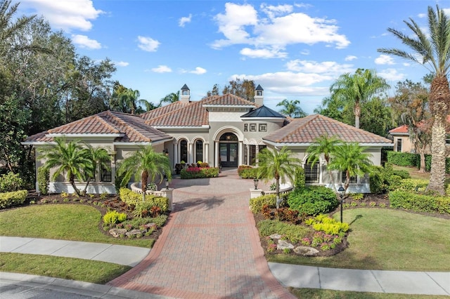 mediterranean / spanish house with a front lawn