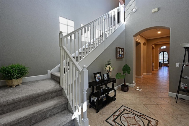 stairs featuring tile patterned floors and crown molding